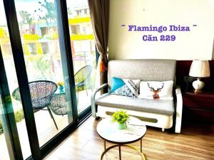 a living room with a couch and a table at Flamingo Hải Tiến IBIZA in Gò Ba Quần