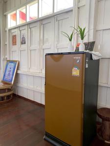 een bruine en zwarte koelkast in een kamer bij Khun Cham-nan Herb Garden House in Phichai