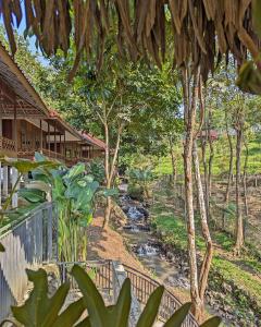 a stream in front of a house with trees at Kasuari Exotic Resort Magelang in Magelang