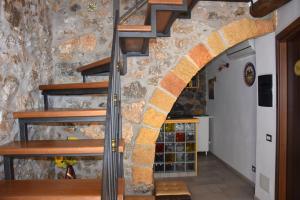 a stone wall with a spiral staircase in a house at La Casa del Geko in Cefalù