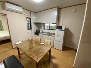 a small room with a table and a kitchen at ゲストハウスえらぶー7 in Wadomari