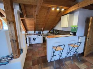 a kitchen with two bar stools and a counter at Ferienwohnung zum Forsthaus mit Sauna in Oberviechtach