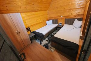 two beds in a small room with wooden walls at Everest Rest House in Tsaghkadzor