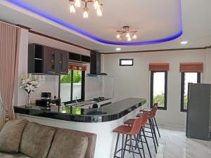 a kitchen with a counter with a bar with stools at Kannaphat Villa in Ko Phangan