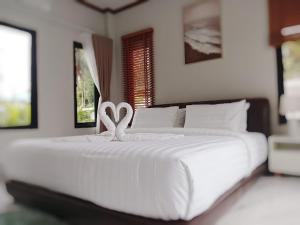 a large white bed with two swans on it at Kannaphat Villa in Ko Phangan