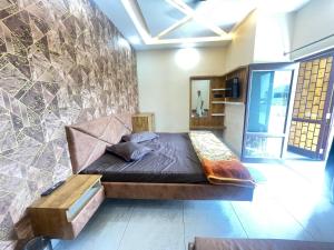 a bed in a room with a stone wall at Hasrat Residency in Jagādhri