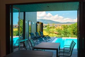 a patio with tables and chairs next to a swimming pool at POOL VILLA 莉-rei- in Takashima