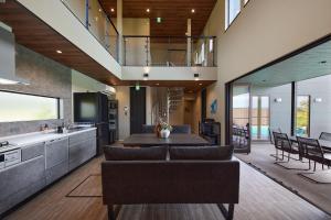 a kitchen and living room with a couch and a table at POOL VILLA 莉-rei- in Takashima