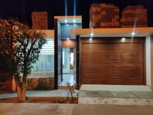 a house with a wooden garage door at night at Casa Oasis Meneses in Ica