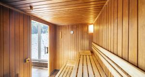 a wooden bench in a sauna with a window at PLAZA Premium Salzburg in Salzburg