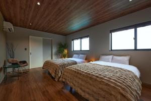 a bedroom with two beds and two windows at POOL VILLA 莉-rei- in Takashima +74 photos