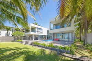 an exterior view of a house with palm trees at Ocean Villas Da Nang in Danang