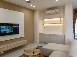 a living room with a couch and a flat screen tv at Villa Hồ Tràm 3636 in Xuyên Mộc