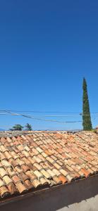 a tile roof of a building with a tree in the background at Apartman's Villi in Jadranovo