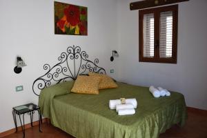 a bedroom with a green bed with towels on it at La Casa del Geko in Cefalù