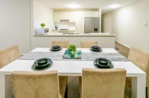 a dining room with a white table and chairs at Norwest business park in Baulkham Hills