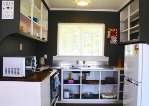 a kitchen with a sink and a microwave at Waitangi Beach Unit A in Paihia