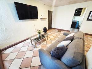 a living room with a couch and a tv at Departamento acogedor y céntrico in Oaxaca City +2 photos
