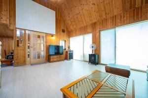 a living room with a table and a tv at Pocheon Rose Garden Pension in Pocheon