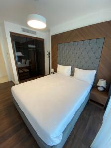 a bedroom with a large white bed with a large headboard at Grand Sapphire 2 bedroom in Saint Yeorgios +7 photos