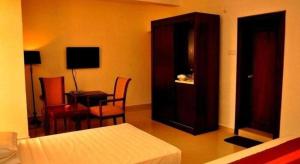 a bedroom with a bed and a cabinet and a desk at Sai Sea City Hotel in Colombo +101 photos