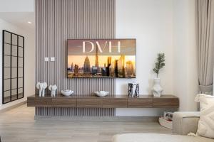 a living room with a dhm painting on the wall at DVH Luxe Retreats 2BR Yas Island by Ferrari World & Yas Mall in Abu Dhabi