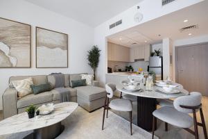 a living room with a couch and a table and chairs at DVH Luxe Retreats 2BR Yas Island by Ferrari World & Yas Mall in Abu Dhabi