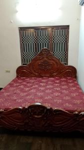 een groot houten bed met een houten hoofdeinde bij Home Nest in Hyderabad