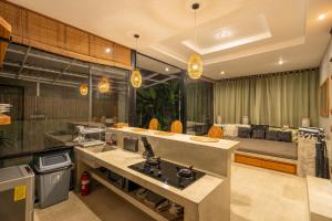 a kitchen with a counter and a couch in the background at Kalino Villa by Betterplace in Canggu