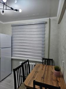 a kitchen with a wooden table and a refrigerator at Квартира однокомнатная in Balqash +2 photos