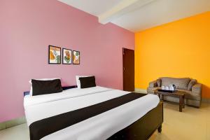 パトナーにあるSuper Hotel O Patliputra Bus Terminal Formerly Awadh Palaceの大きなベッドと椅子のある寝室
