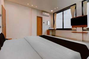 a bedroom with a large bed and a tv at Super Collection O Aurangabad Shendra MIDC Formerly Prayag Inn in Karmād +21 photos