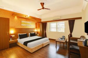 马迪凯里Super Townhouse Oak City Center Kushal Nagar的一间配有床和电视的酒店房间