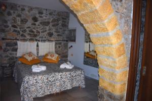a bedroom with a bed and a stone wall at La Casa del Geko in Cefalù