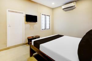 a bedroom with a white bed and a television at Hotel O THE IMPERIAL INN in Chennai