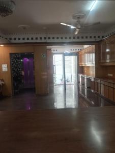 a large kitchen with wooden cabinets and a ceiling fan at Home Sweet place in Meerut