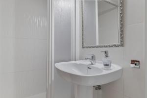 ein weißes Badezimmer mit Waschbecken und Spiegel in der Unterkunft Apartamento en Vejer in Vejer de la Frontera + 15 Fotos