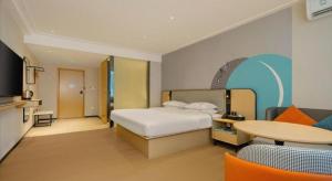 a hotel room with a bed and a table and chairs at City Comfort Inn Dongxing National Trade Port in Tung-hsing-shih +161 photos