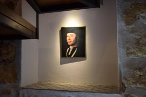a painting of a man in a suit on a wall at La Casa del Geko in Cefalù
