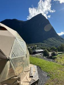 a dome tent with a mountain in the background at Vollsnes Glamping in Hjelle