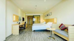 a hotel room with a bed and a couch at City Comfort Inn Huizhou Economic College Shuikou Huxi Avenue in Huizhou +229 photos