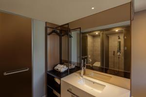 a bathroom with a sink and a large mirror at NewCZ Gwangan Hotel in Busan