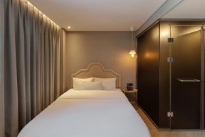 a hotel room with a bed and a shower at NewCZ Gwangan Hotel in Busan