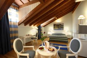 a room with a bed and a table and chairs at Casa Romagnosi in Salsomaggiore Terme