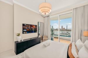 une chambre avec un lit blanc et une grande fenêtre dans l'établissement Luxury 2BR Retreat Gorgeous Beach & Skyline Views, à Dubaï