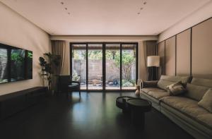 a living room with a couch and a large window at Huguang Hidden Villa Hotel in Chongqing