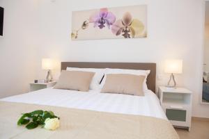 Un dormitorio con una cama blanca con flores. en Summer Lounge Apartments, en Split