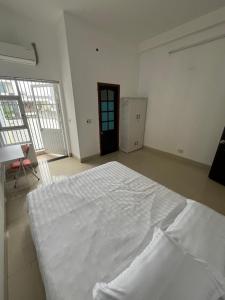 a large white bedroom with a large bed in it at Grandma Vuong's House & Café in Da Nang