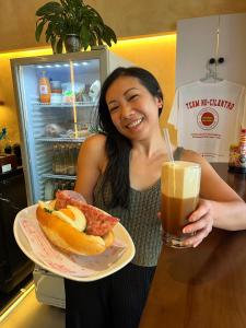 a woman holding a plate of food and a drink at Grandma Vuong's House & Café in Da Nang