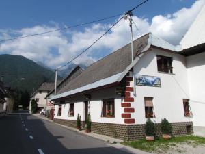 ein weißes Gebäude an der Straßenseite in der Unterkunft Joe's Place in Log pod Mangartom